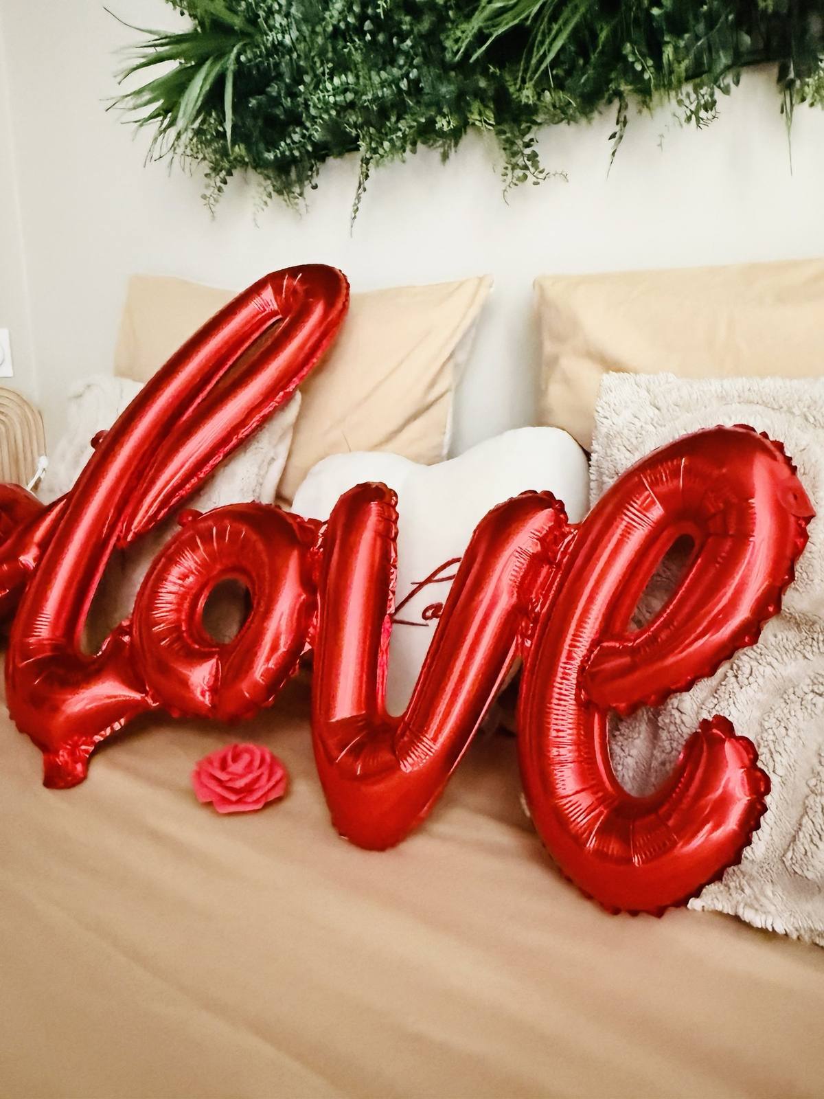 Ballon rouge en forme de mot love sur le lit