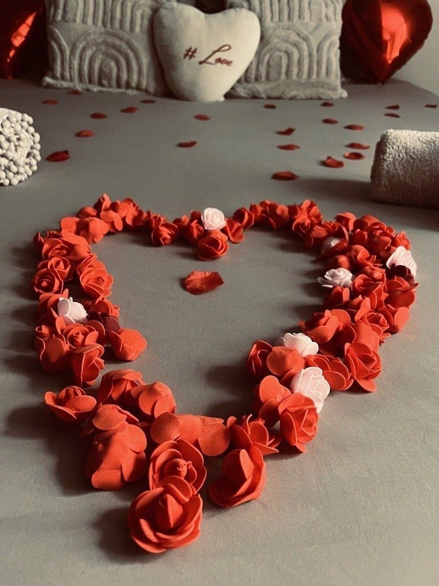 Cœur de roses rouges sur le lit