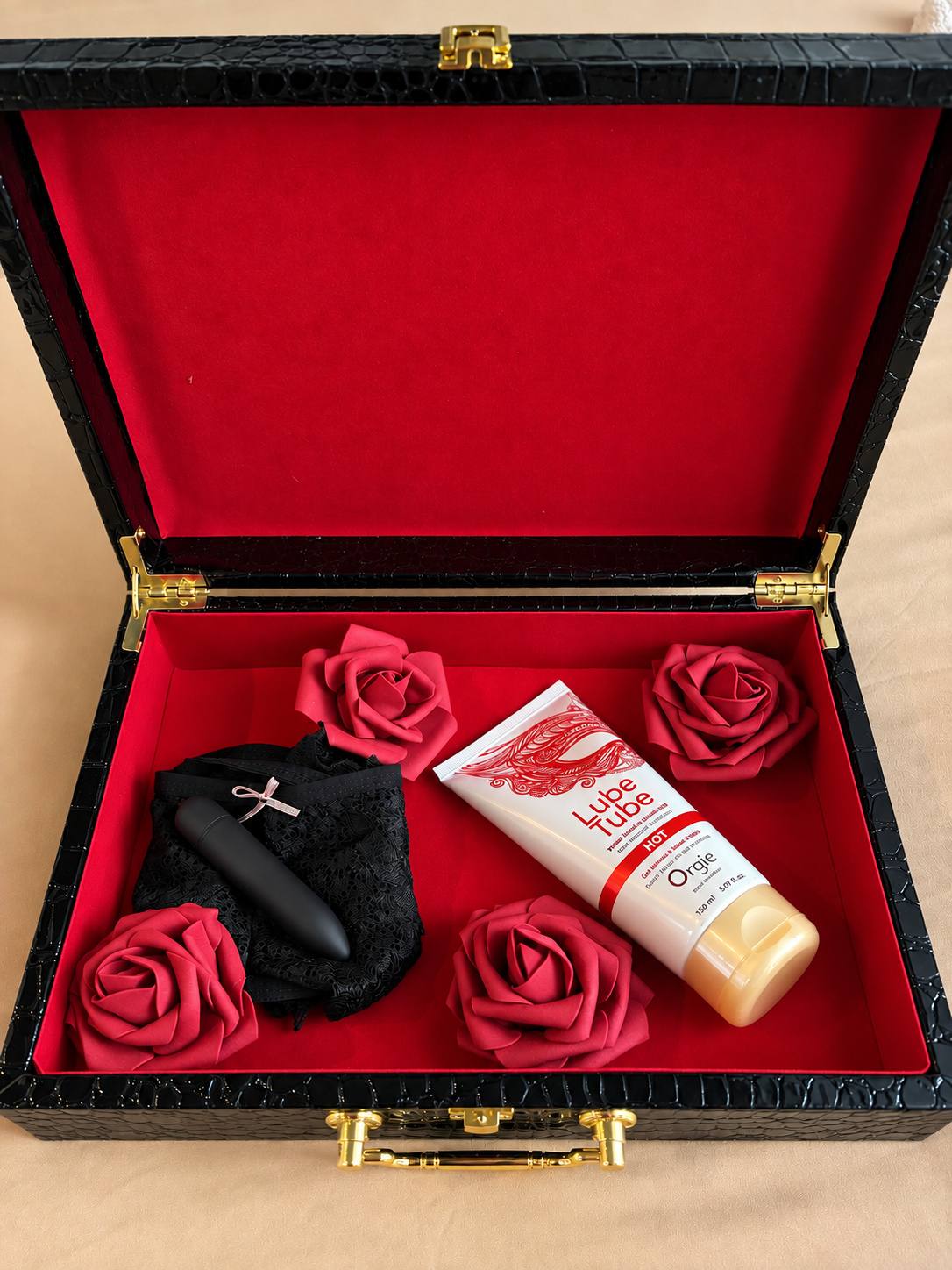 Coffret noir ouvert avec masque et gel de massage