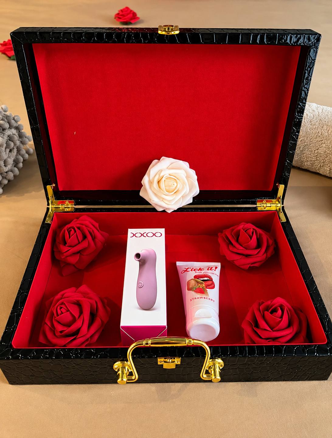 Coffret noir ouvert avec accessoires et roses