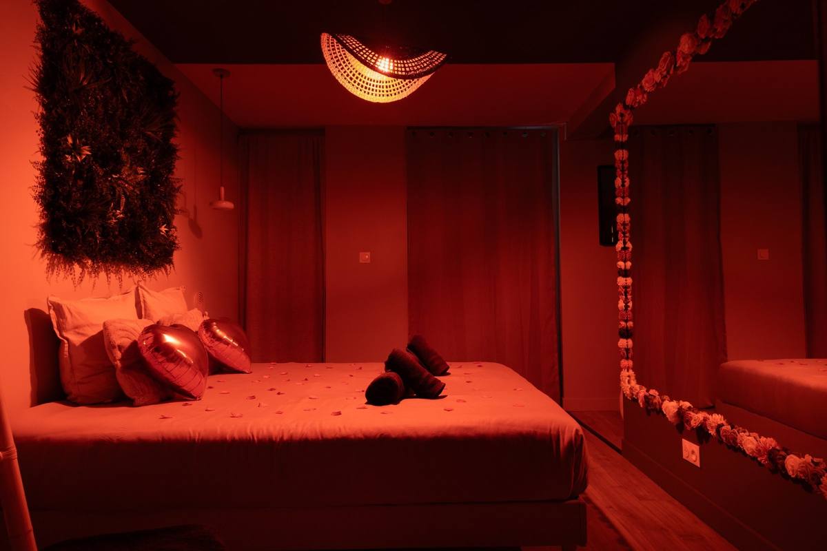 Chambre en lumière rouge, lit King size et suspension