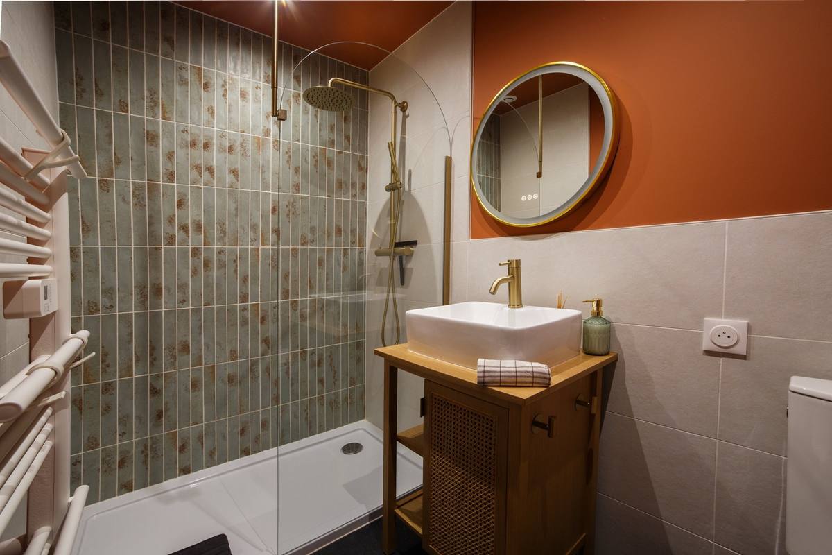 Salle d'eau avec douche à l'italienne et miroir doré