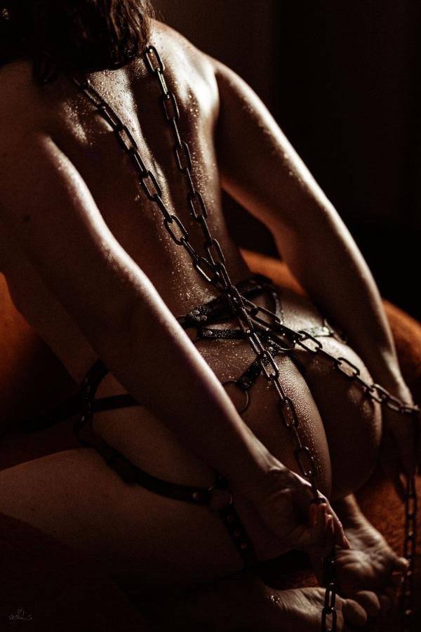 Séance boudoir : dos et chaînes, lumière tamisée